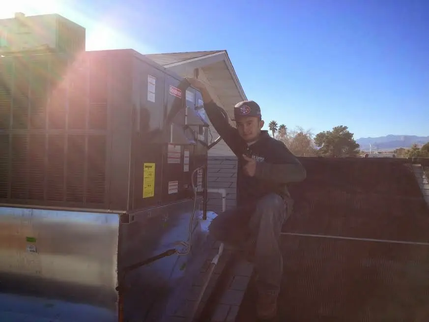 HVAC technician performing Boiler Repair on a rooftop unit in Seven Hills